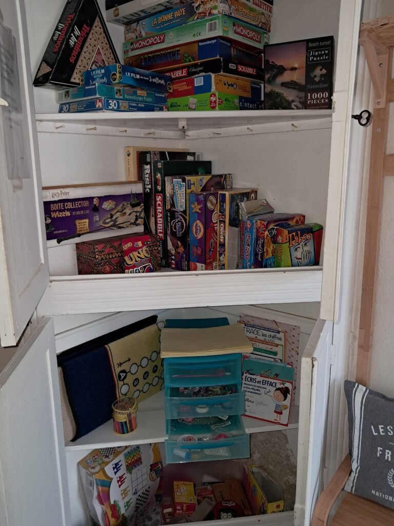 Étagère remplie de jeux de société variés pour les soirées en famille ou entre amis, dans le gîte Les P'tites Cagouilles